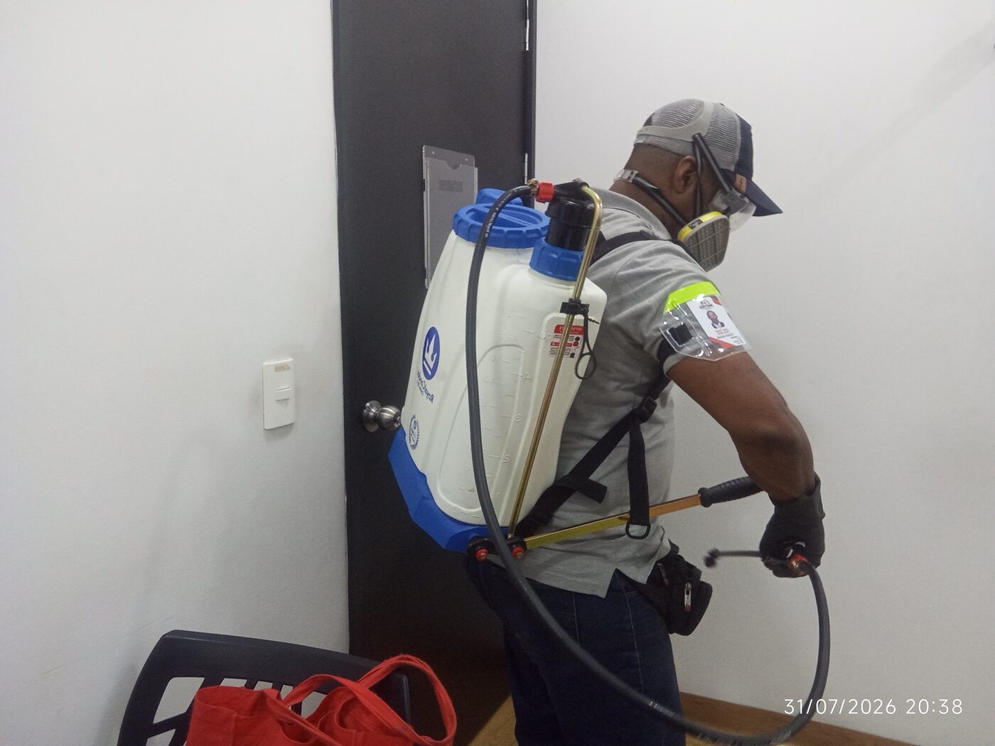 Tecnico certificado de Fumigaciones Magistrales Del Valle aplicando tratamiento con equipo de aspersion en Cali