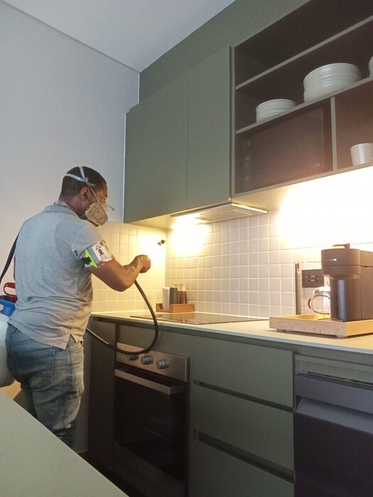 Fumigación residencial: técnico aplicando tratamiento en la cocina de un apartamento en Cali
